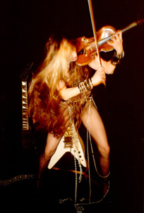ENTS24 FEATURES THE GREAT KAT! "The Great Kat. AKA Katherine Thomas, a classical violin graduate of the famed Juilliard school, who has reinvented herself as a guitar shredder. She is believed to be the fastest female guitarist in the world."